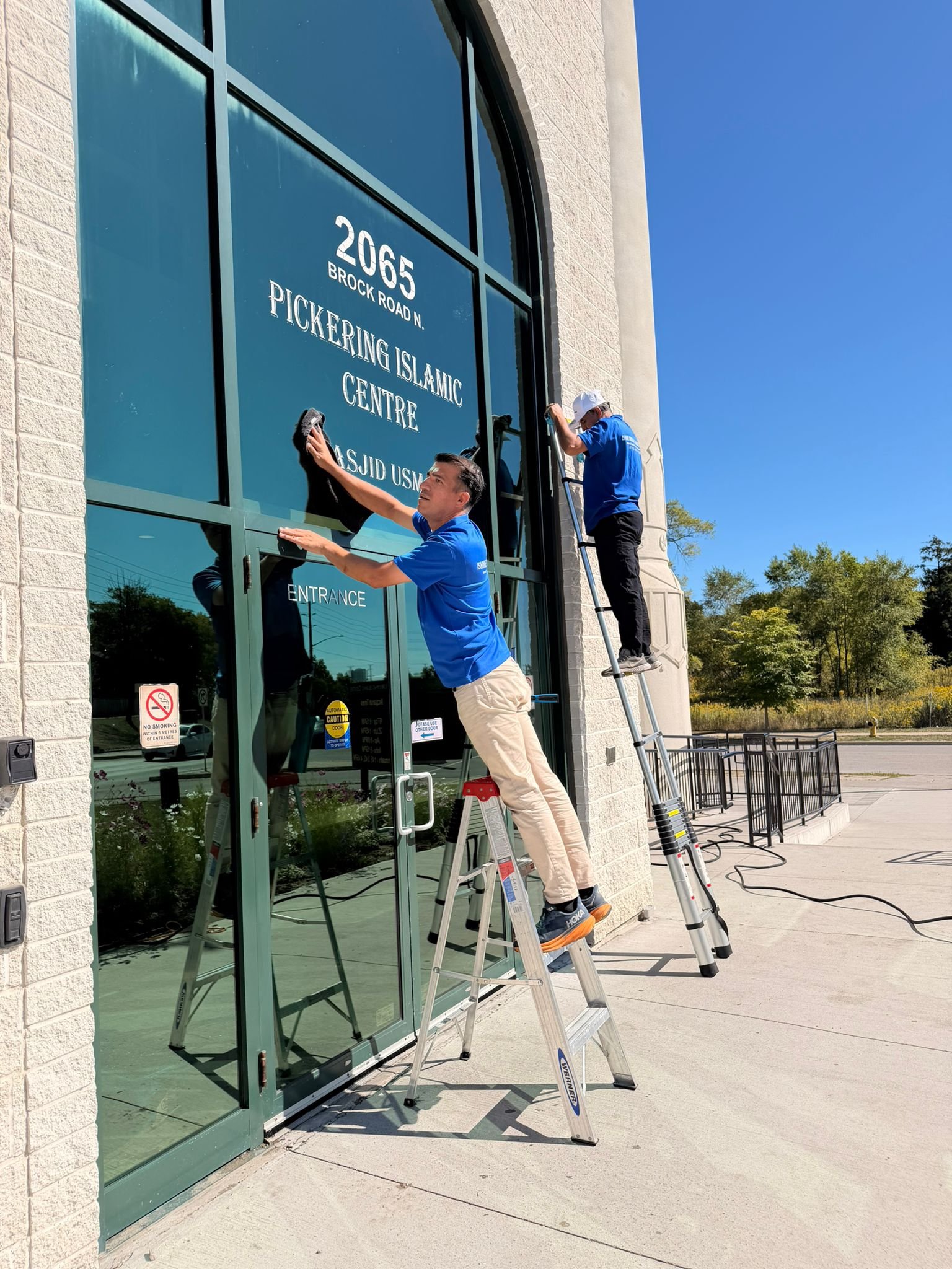 iShine team cleaning high commercial entrance windows in the GTA